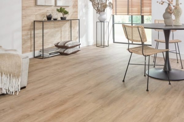 Extra brede landhuis‑PVC plank in zachte eikenlook met subtiele grijze ondertoon, voelbare houtstructuur en mat MEGAMAT‑afwerking.