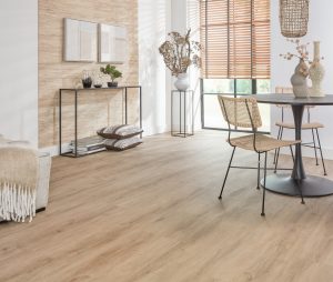 Extra brede landhuis‑PVC plank in zachte eikenlook met subtiele grijze ondertoon, voelbare houtstructuur en mat MEGAMAT‑afwerking.