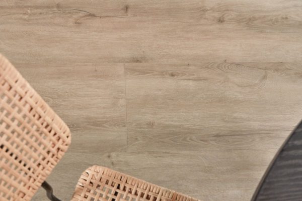 Extra brede landhuis‑PVC plank in zachte eikenlook met subtiele grijze ondertoon, voelbare houtstructuur en mat MEGAMAT‑afwerking.